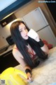 A woman sitting at a kitchen counter holding a cup of coffee.