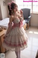 a woman in a pink and white dress standing in a room